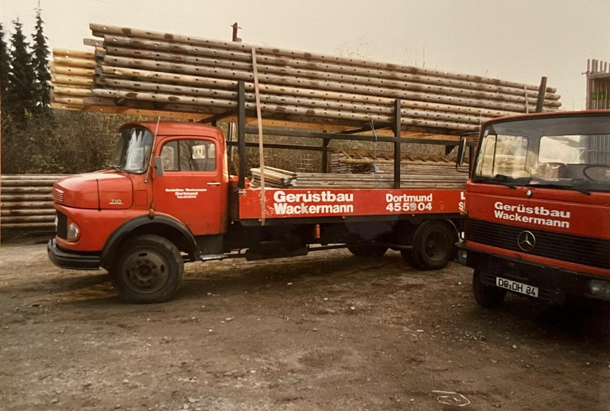 Historisches Foto: rote Wackermann-LKW, beladen mit Gerüststangen