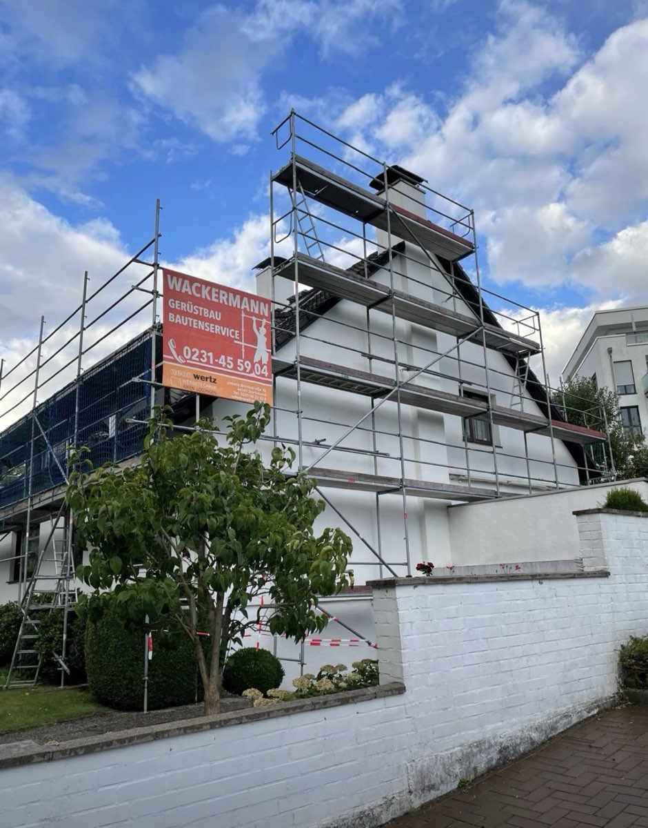 Eingerüstetes Wohnhaus mit Gerüst bis über den Schornstein