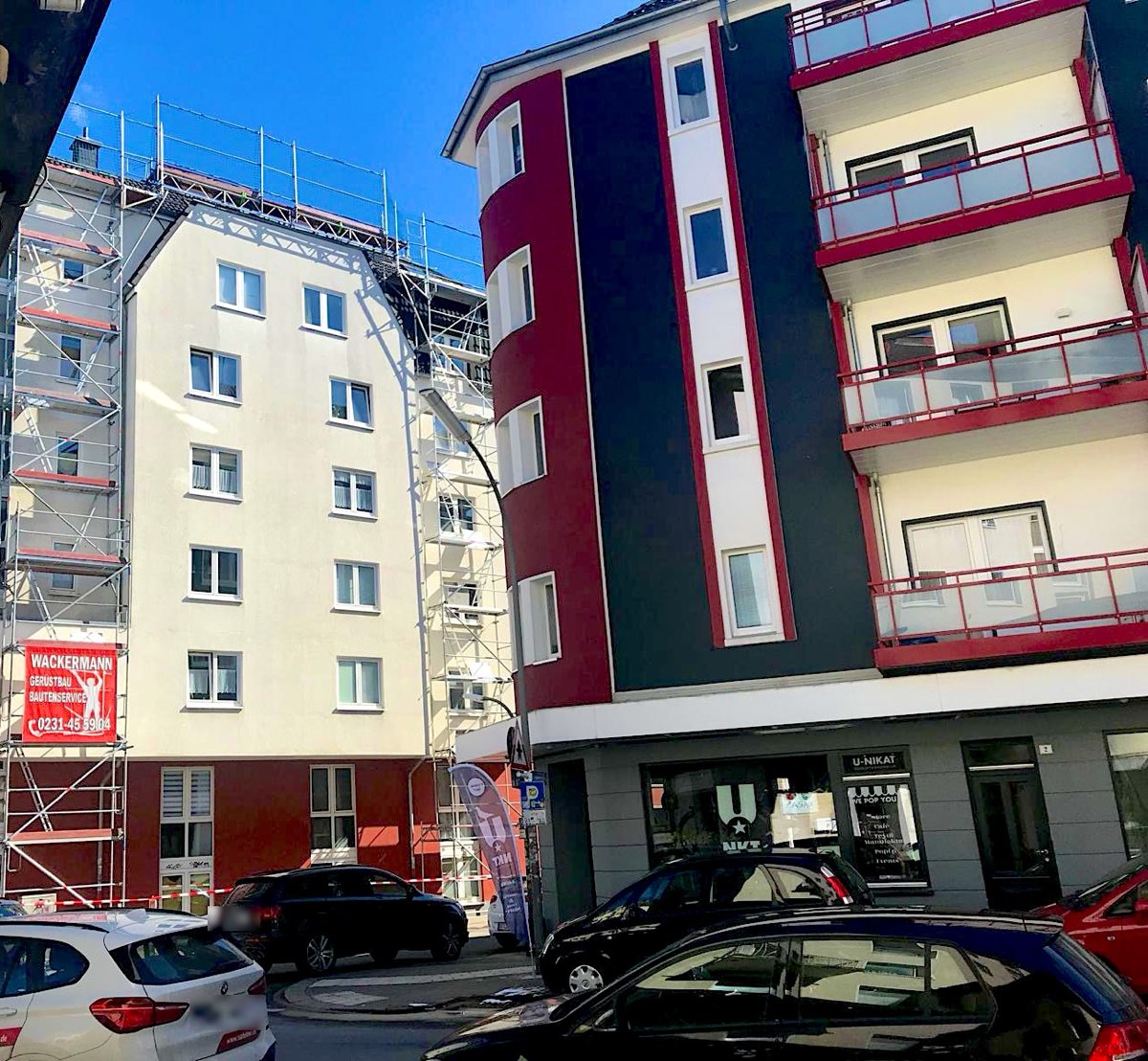Wohn- und Geschäftshaus mit Fassadengerüst und Wackermann-Banner