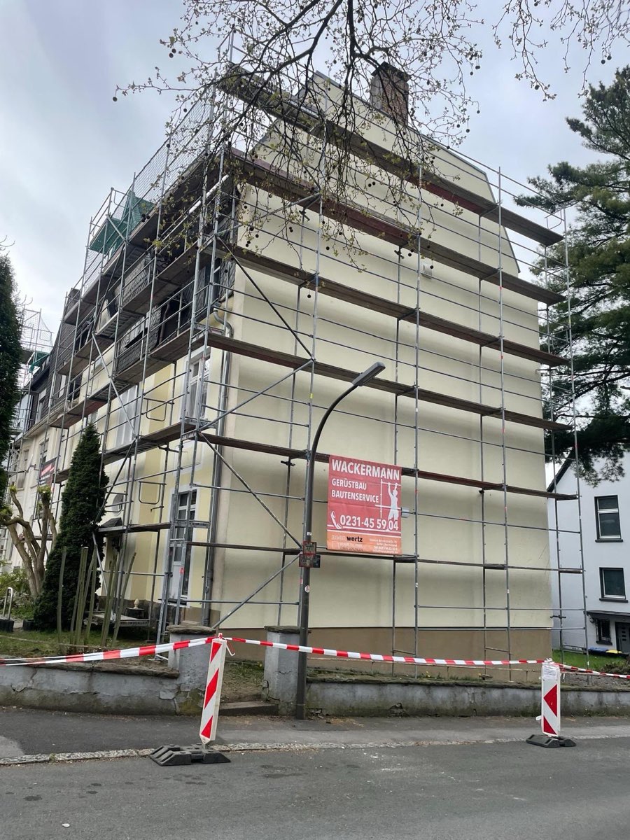 Fassadengerüst an einem mehrstöckigen Wohnhaus mit abgesperrtem Gehweg
