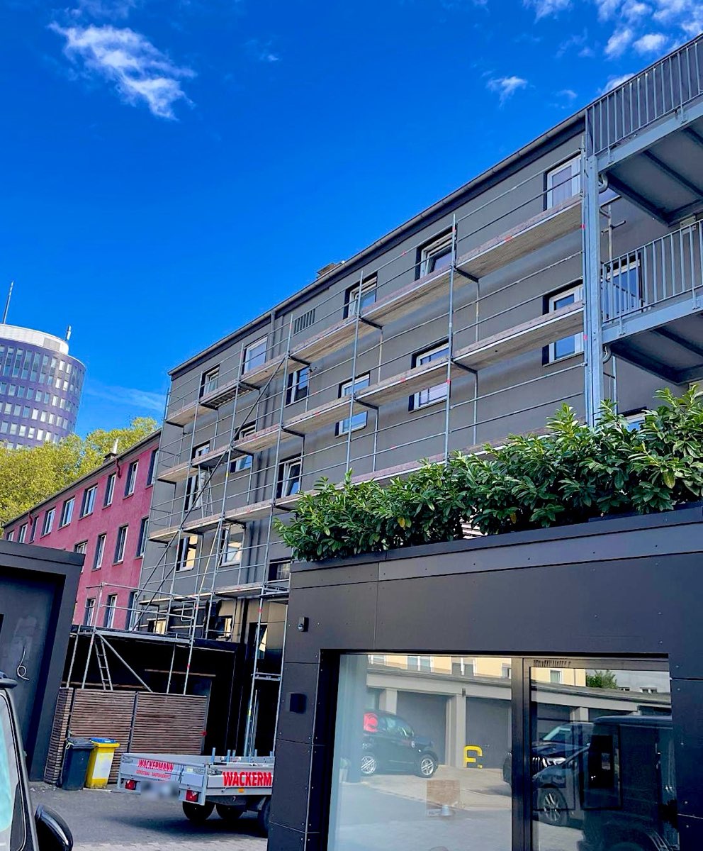Stadthaus mit Fassadengerüst, im Hintergrund ein Dortmunder Hochhaus
